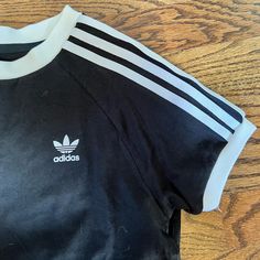 Never Worn, But Tags Removed. True Black With White Adidas Lines That Are From Strong Woven Fabric Not Just Cotton. Black Crew Neck T-shirt With Three Stripes, Black Three Stripes Crew Neck T-shirt, Casual Black T-shirt With Three Stripes, Black T-shirt With Three Stripes, Black Cotton Top With Three Stripes, Black Cotton Tops With Three Stripes, Black Cotton T-shirt With Three Stripes, Adidas Black Tops With Three Stripes, Downtown Girl