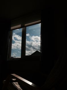 a window in a dark room with the sky outside