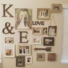 a wall filled with pictures and letters on top of a wooden table next to a window