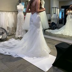 a woman is looking at her wedding dress in the mirror