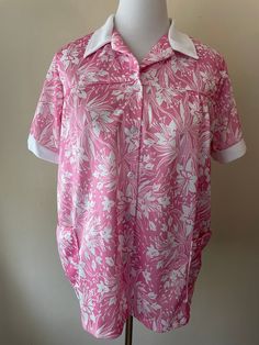 "Vintage 70s button down collared shirt. Collar and sleeves are white, two front waist pockets. Marked size 42, pink and white floral pattern. Please ask questions!  Measurements (laid flat):  Tag Size: 42 Length: 26.5\" Pit to Pit: 22.5\"x2 Waist: 24\"x2 Condition: Excellent vintage condition, no issues noted.  The vintage pieces I sell have all led a previous life and may tell their stories through minor imperfections. I'll do my best to indicate overall condition, but please refer to the pictures. Your purchase continues the life of this garment...what stories will you tell while wearing it?  Please note there may be a slight difference in color when comparing the actual garment to the monitor image. (0460)" Retro Pink Button-up Top, Vintage Pink Shirt With Button Closure, Retro Pink Collared Tops, Retro Pink Shirt With Buttons, Pink Floral Print Collared Blouse, Pink Retro Shirt With Buttons, Vintage Pink Buttoned Shirt, Vintage Pink Shirt With Buttons, Vintage Pink Collared Shirt