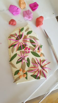 a piece of cake sitting on top of a cutting board next to scissors and paper