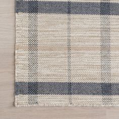 an area rug with blue and white checkered fabric on top of a wooden floor