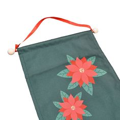 a green bag with red flowers on it