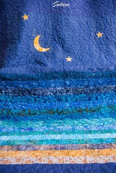 a blue quilt with stars and moon on it