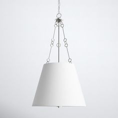 a white lamp hanging from a metal chain with a light shade on it's side