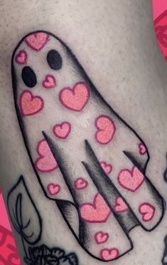 a close up of a person's leg with hearts on it and a ghost