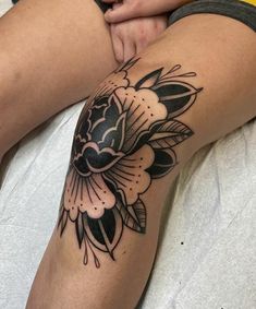 a woman's leg with a flower tattoo on her thigh and the bottom half of her legs