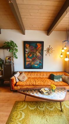 a living room filled with furniture and a painting on the wall above it's coffee table