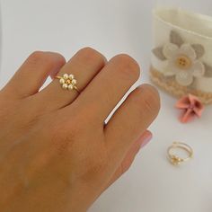 Dainty daisy ring Measures in millimeters: * Jewelry wire: 1 mm * Gold plated metal bead: 3 mm * Pearls: 3 mm Care Information: * FLEXIBLE RING, so it must be handled with care. If the ring loses its shape, you can easily wrap it around a round object to return it to shape. * Avoid contact with water and products such as perfumes and creams. * Store it in a dry place. Shipment information: * Purchases will ship within 1-2 business days. * I'll send this item in a nice cloth bag so you have somewhere to store it when you're not using it. If you have any questions send me a message. Thanks for visiting 💗 Flower Bead Ring, Pearl Flower Ring, Daisy Jewelry, Ring Wire, Wire Flowers, Daisy Ring, Metal Bead, Simple Gift, Swirl Ring