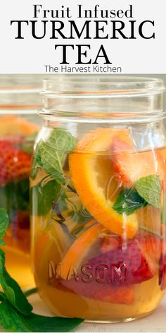 fruit infused tumericic tea in a jar with strawberries and oranges