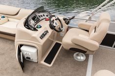 the inside of a boat with steering wheel and seats