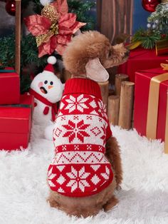 a dog wearing a red sweater next to christmas presents