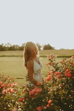 a woman standing in the middle of flowers