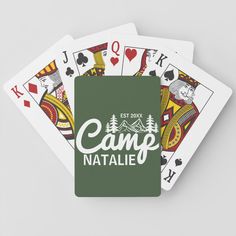 the camp natale playing cards are green and have white lettering on each card deck