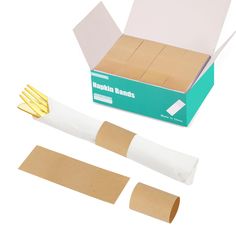 a cardboard box with several pieces of paper taped to it and some gold scissors next to it