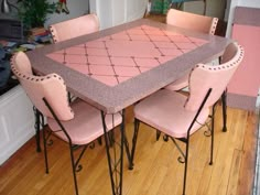 a dining room table with pink chairs around it