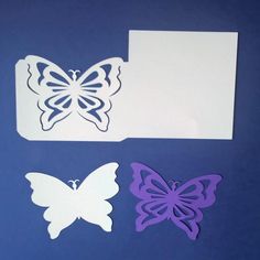 three butterflies cut out of paper on a blue background