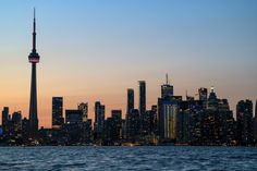 the skyline of toronto is lit up at night, as seen from across the water