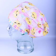 a white hat with yellow and pink flowers on it sitting on top of a head