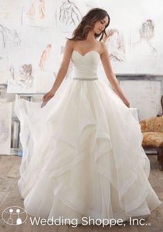 a woman in a white wedding dress is posing for the camera with her hands on her hips