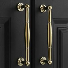 two golden handles on black doors with gold knobs in the center and bottom part