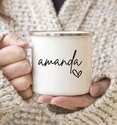 a woman holding a white coffee mug with the word amanda written on it in black ink