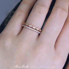 a woman's hand with two wedding bands on her ring, and the other half is