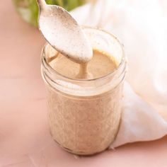 a spoon is sticking out of a jar filled with some kind of food that's in it