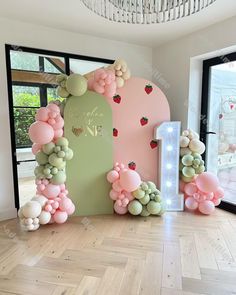 the balloon arch is decorated with strawberrys and balloons