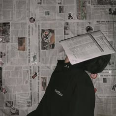 a person with a book on their head and newspaper covering his face, reading the paper