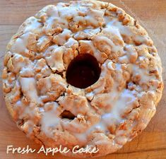 a fresh apple cake with icing on a wooden table