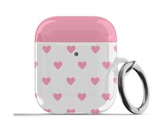 a pink and white cup with hearts on it next to a pair of metal rings