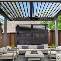 an outdoor living area with couches, tables and a ceiling fan in the background