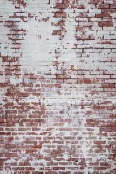 an old red brick wall with white paint