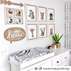 a baby's room with pictures on the wall