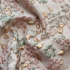 the fabric has gold and pink flowers on it