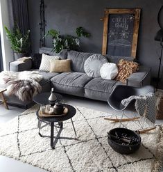 a living room filled with furniture and lots of pillows on top of a white rug