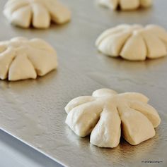 six uncooked buns sitting on top of a baking sheet