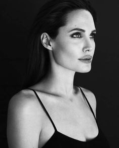 a black and white photo of a woman with long dark hair wearing a tank top