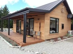 a small wooden house sitting on top of a gravel field