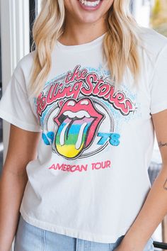 a woman with blonde hair wearing a white rolling stones t - shirt