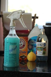 a bottle of cleaner sitting on top of a counter next to lemons and other cleaning products