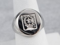 This signet ring is heavy and impressive! Crafted of luxurious platinum, this ring depicts a fleur de lis, crown, and laurel wreath emblem that is carved with great detail. Please note that this signet ring has its original monogram, and unfortunately, this piece cannot be altered without affecting the quality of the piece. Please feel free to contact us to help you find your perfect signet ring in your style and budget! Metal: Platinum Top Measurements: 14 x 16 mm, Oval Ring Size: 8 Marks: "PLA Ring Crown, Top Measurements, Cameo Ring, Right Hand Rings, Laurel Wreath, Oval Ring, Oval Rings, Platinum Ring, London Blue Topaz