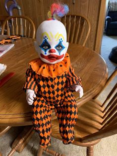 a clown doll sitting on top of a wooden table