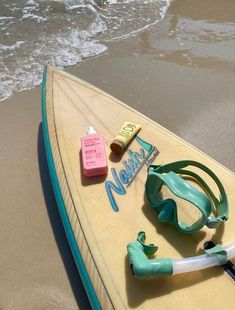 a surfboard with snorkels and other items on the beach