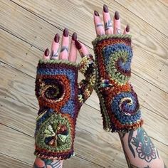 a woman's hand with two crocheted gloves on it