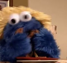 a blue stuffed animal sitting on top of a table