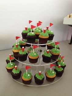 cupcakes with green frosting and red flags are arranged on a cake stand