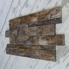 a wooden wall hanging on the side of a white painted wood planked wall,